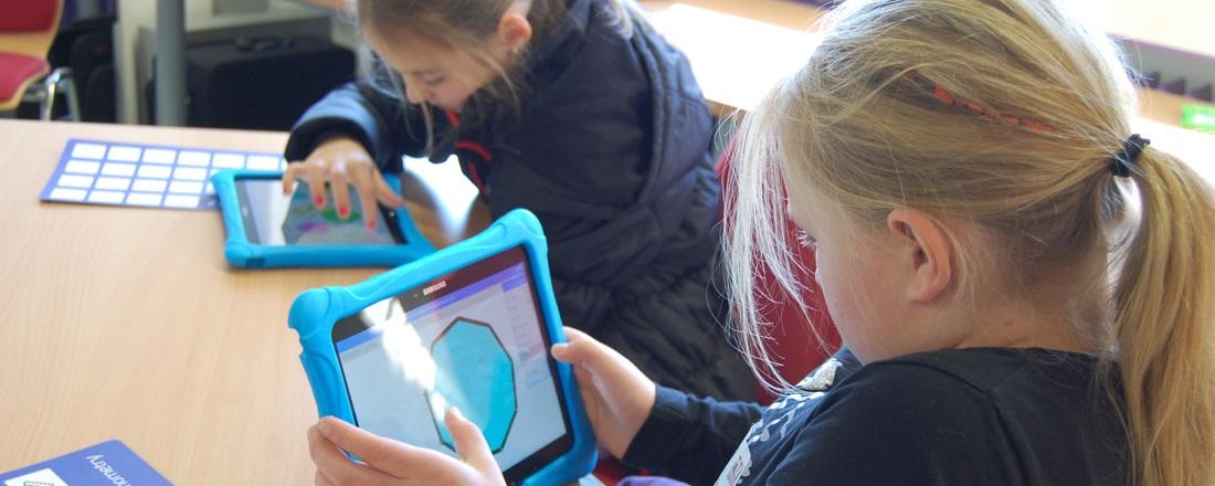 Schülerinnen arbeiten mit Tablet an Geometrieprogramm